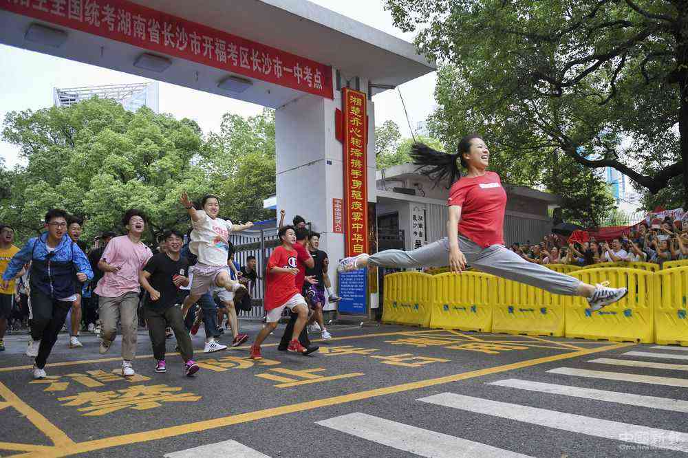 7月8日，高考结束，长沙市第一中学高考考生罗子欣（右）冲出考点大门后以“一字马”姿态跃起。她和小伙伴们早就约好，要以一个特殊的方式纪念高中生活结束。新华社发（辜鹏博 摄）