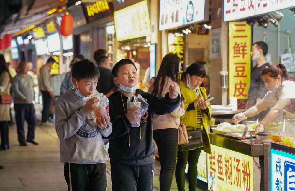 两个男孩在武汉市著名的小吃街户部巷逛街（3月28日摄）。新华社记者 程敏 摄