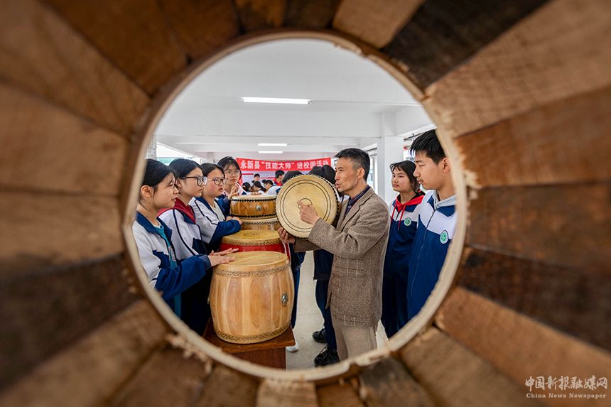 近日，江西省吉安市永新县开展技能大师进校园活动。当地制鼓技能大师在给孩子们传授制鼓技艺。王惠民摄